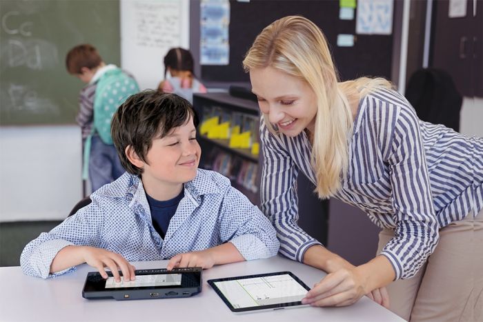 Image of a student using the BrailleNote Touch Plus with their teacher.