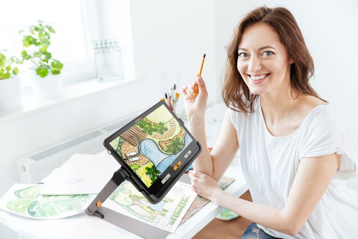 Image of a woman using the explorē 12 with the stand to draw.