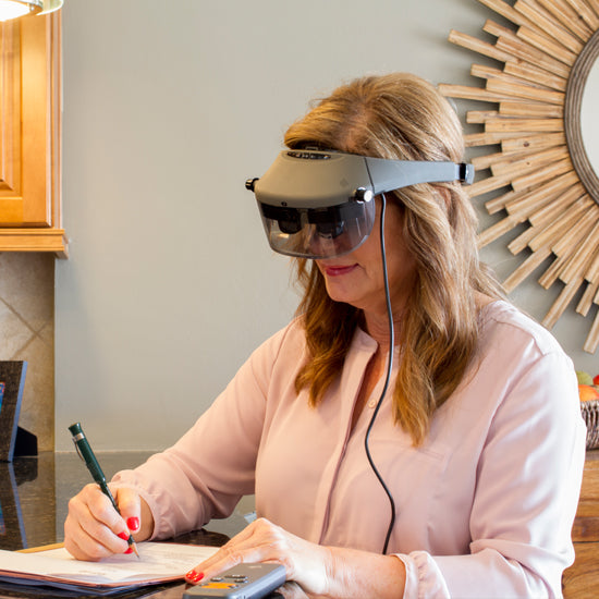 Image of a woman wearing the Acesight smart glasses  while writing.